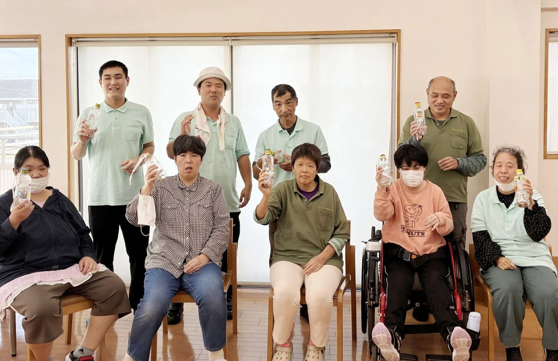 ペットボトルを手に笑顔でポーズをとるチャレンジサポートたかはまの皆さん