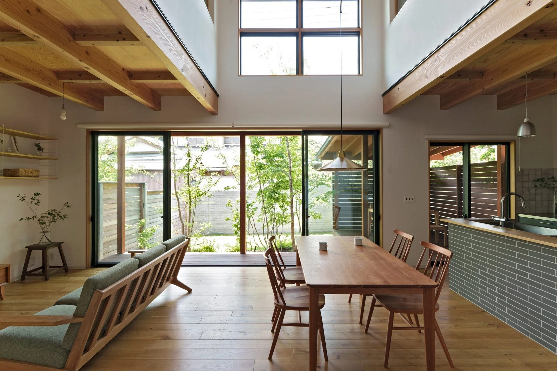 木製の梁とフローリングが特徴的な、明るく開放的なリビングダイニングルーム