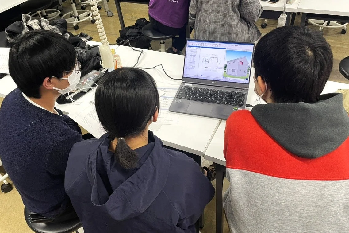 PCを囲んで共同作業をする学生たち