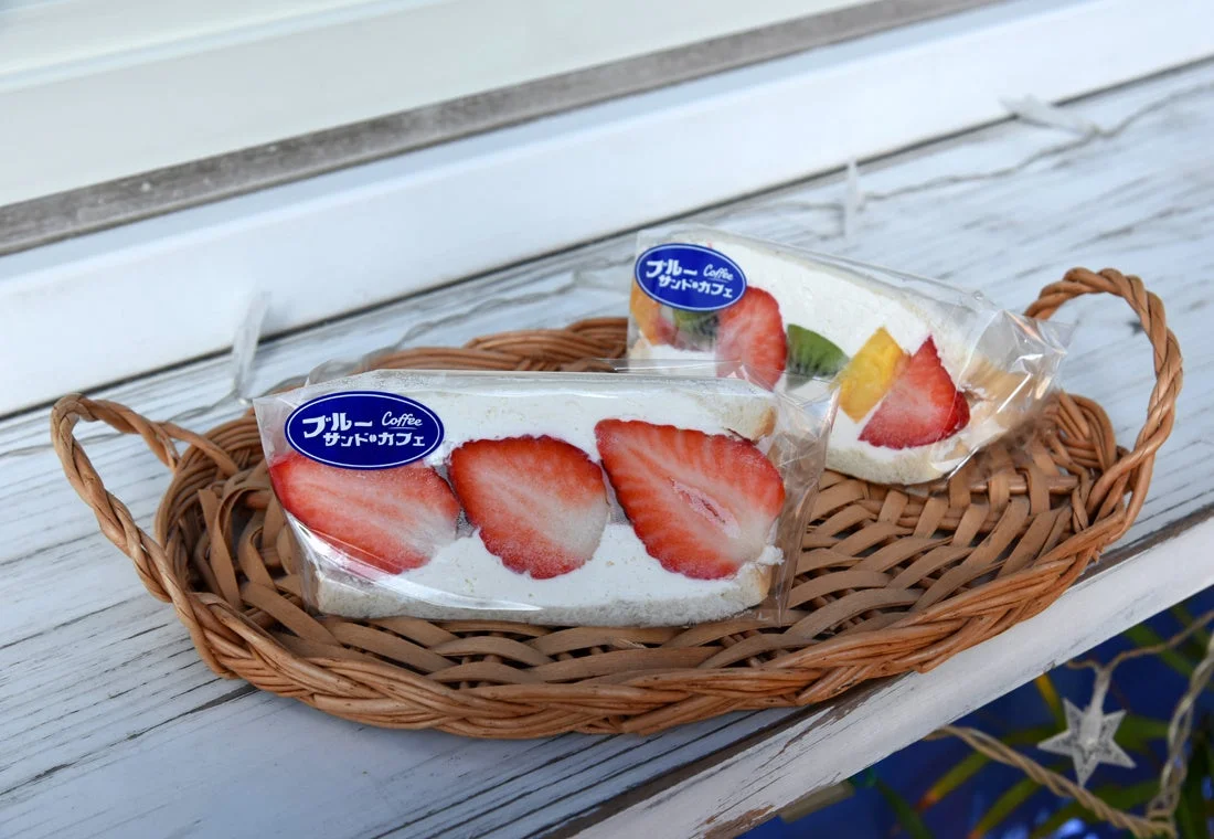 籐のトレイに、生クリームとフレッシュなフルーツを挟んだサンドイッチが2つ並んでいます