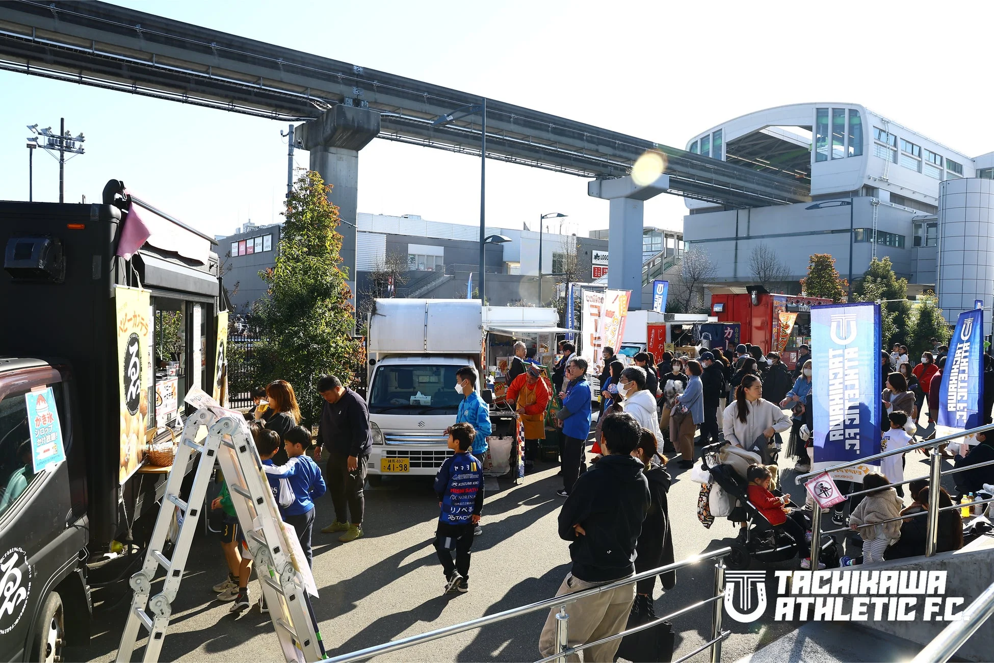 モノレール高架下で開催されている賑やかな屋外イベントの様子