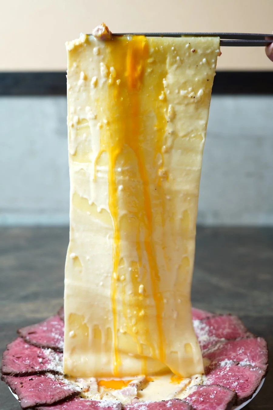 箸で持ち上げられた一枚麺