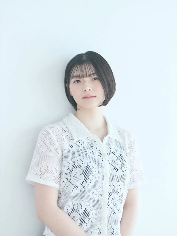 白い背景の前に立つ若い女性のポートレート