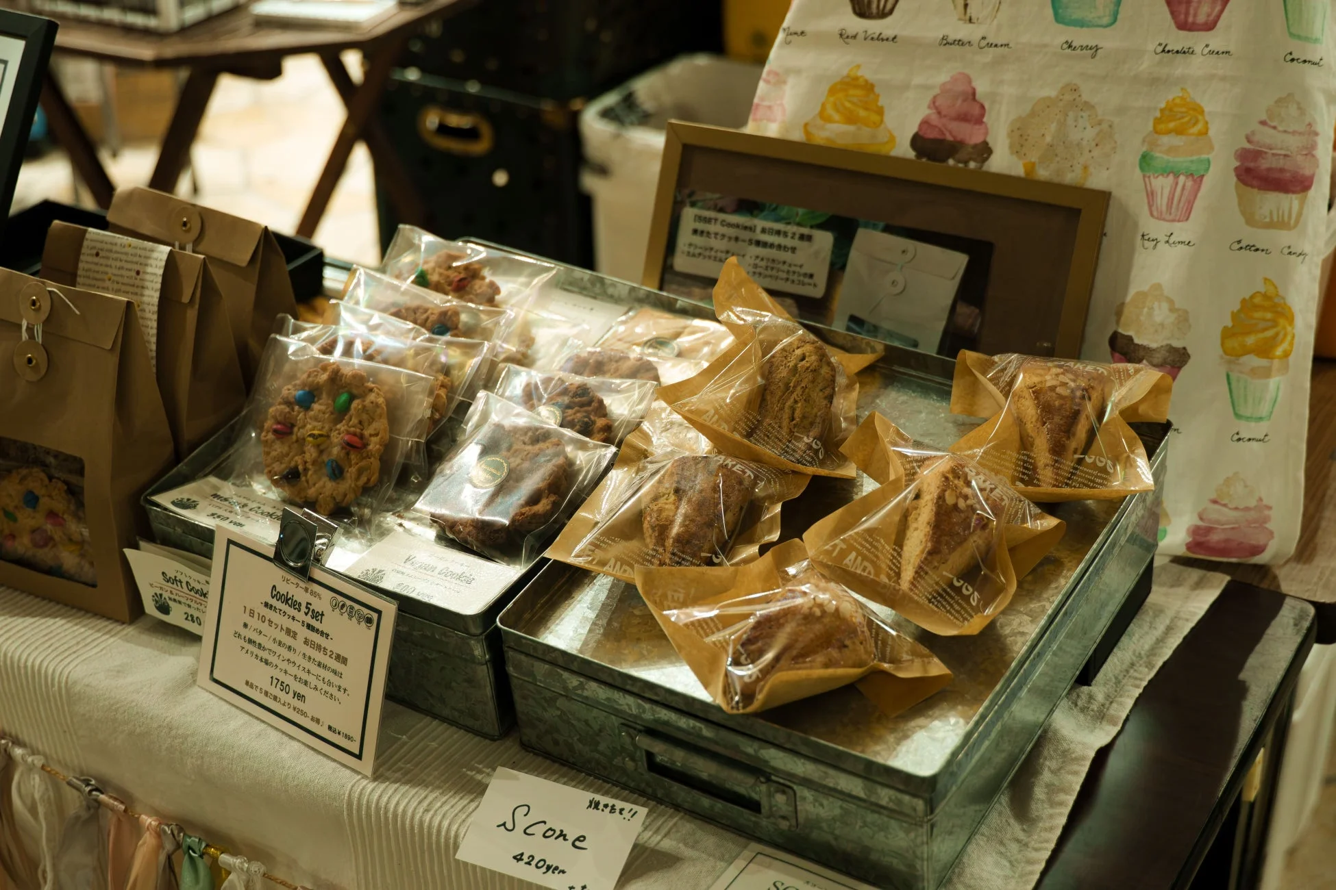 市場かベーカリーで、個包装された様々な種類のクッキーとスコーンが並べられています