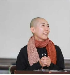 笑顔の坊主頭の女性