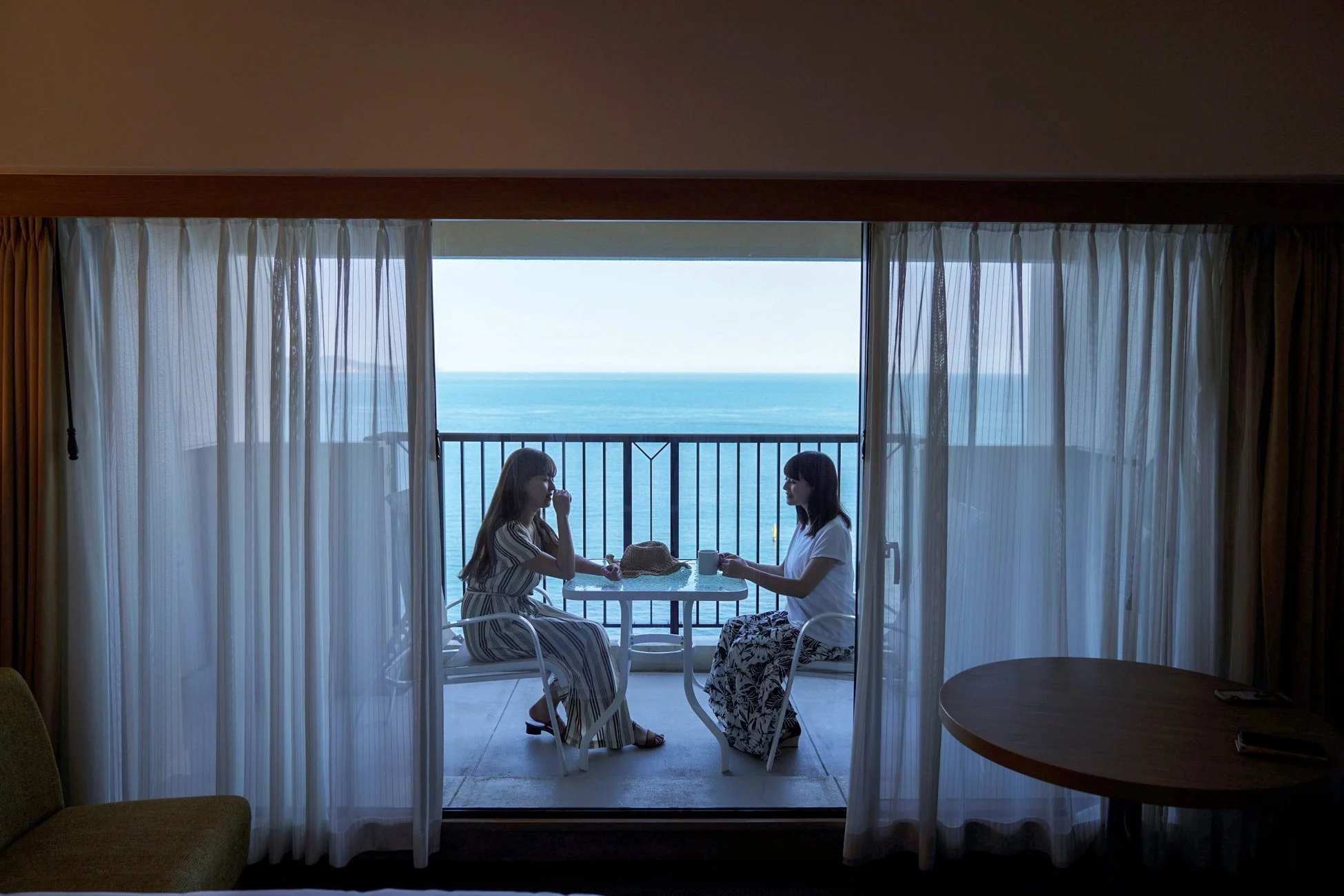 ホテルのバルコニーで会話を楽しむ女性二人