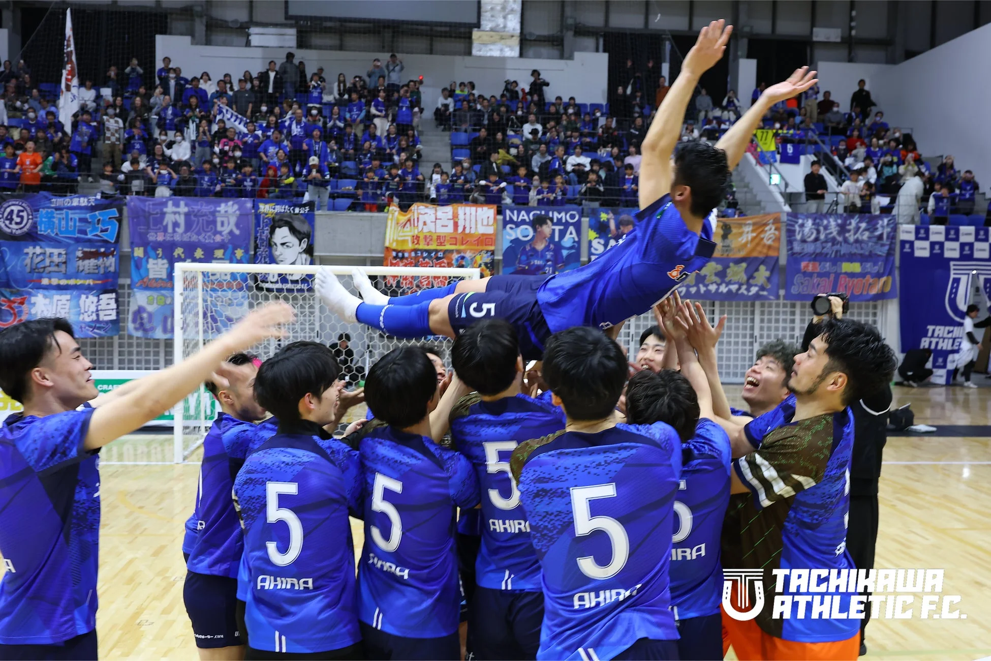 屋内スタジアムで、フットサルチームが勝利を祝う感動的な瞬間