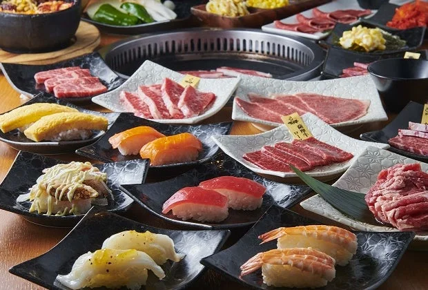 焼肉と寿司が豪華に並べられた食事の風景