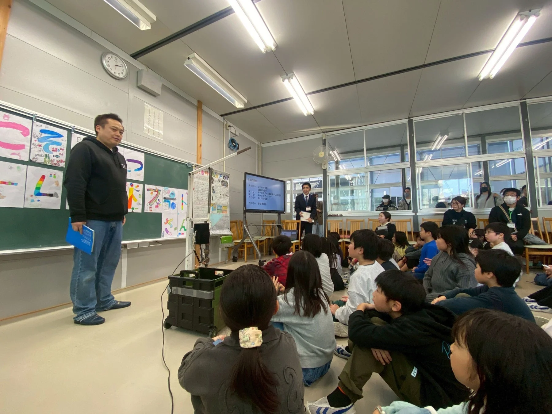 ワークショップで説明を聞く児童たち