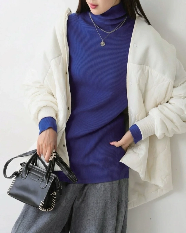 青いリブタートルネックにキルティングジャケットとグレーのワイドパンツを合わせた、冬のきれいめカジュアルコーディネート