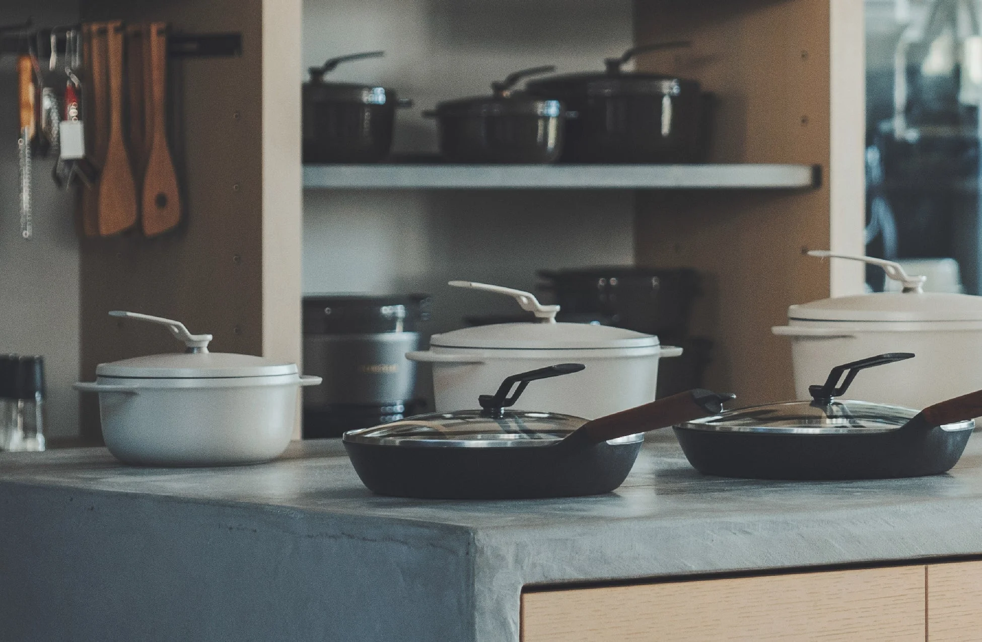 キッチンカウンターに置かれたクリーム色のホーロー鍋と黒いフライパン