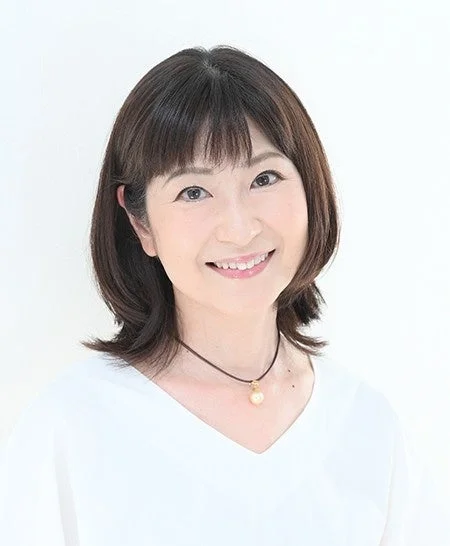 白い背景の前で笑顔を見せるショートヘアの日本人女性のポートレート