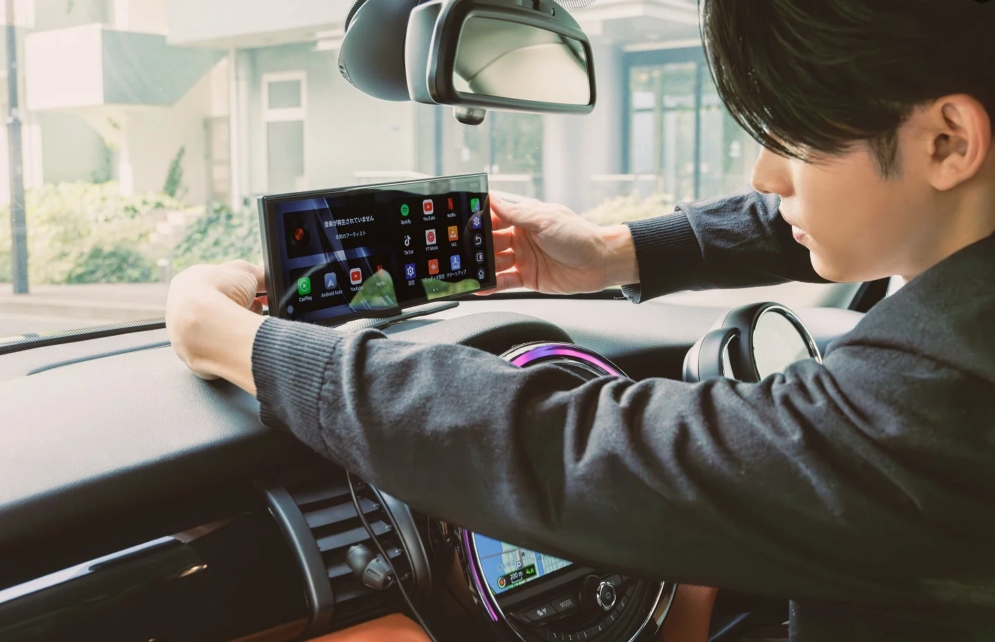 車のダッシュボードにポータブル車載ディスプレイを取り付ける男性