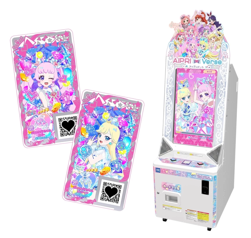 タカラトミーアーツのアーケードゲーム「アイプリバース」の筐体と、キラキラしたデザインの2枚のコレクションカードが写っています。