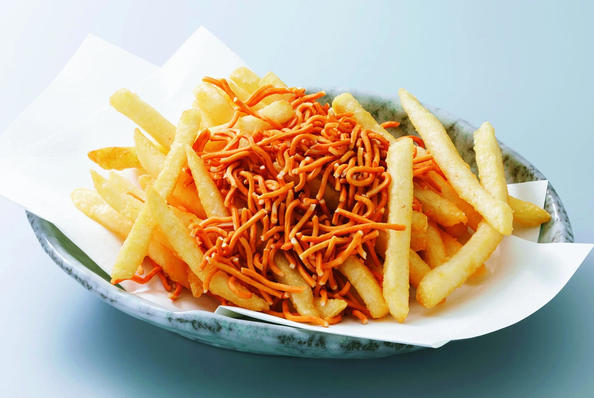 皿に盛られたフライドポテトにベビースターラーメンがたっぷりトッピングされた写真